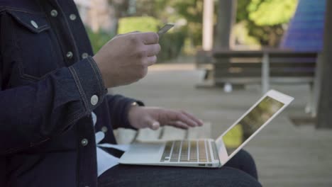 foto recortada de un hombre con tarjeta de crédito usando una computadora portátil