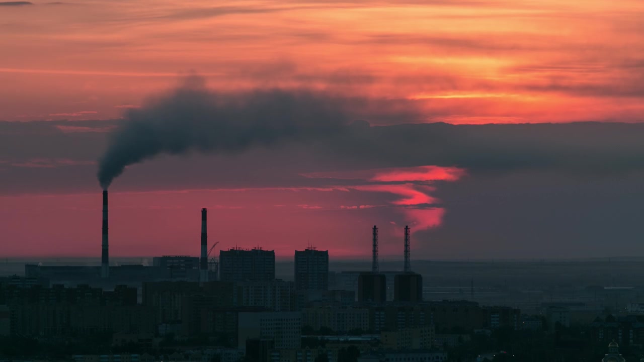Aerial view with sunrise over the city center with smoking pipes and central business district timelapse from rooftop, Nur-Sultan city, Kazakhstan, Central Asia