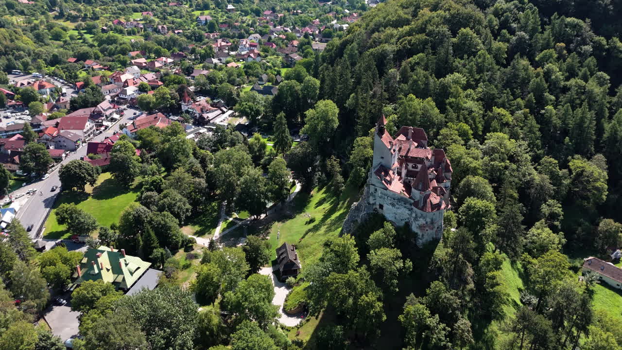 Aerial view of Bran Castle in lush Transylvanian landscape, feeling serene