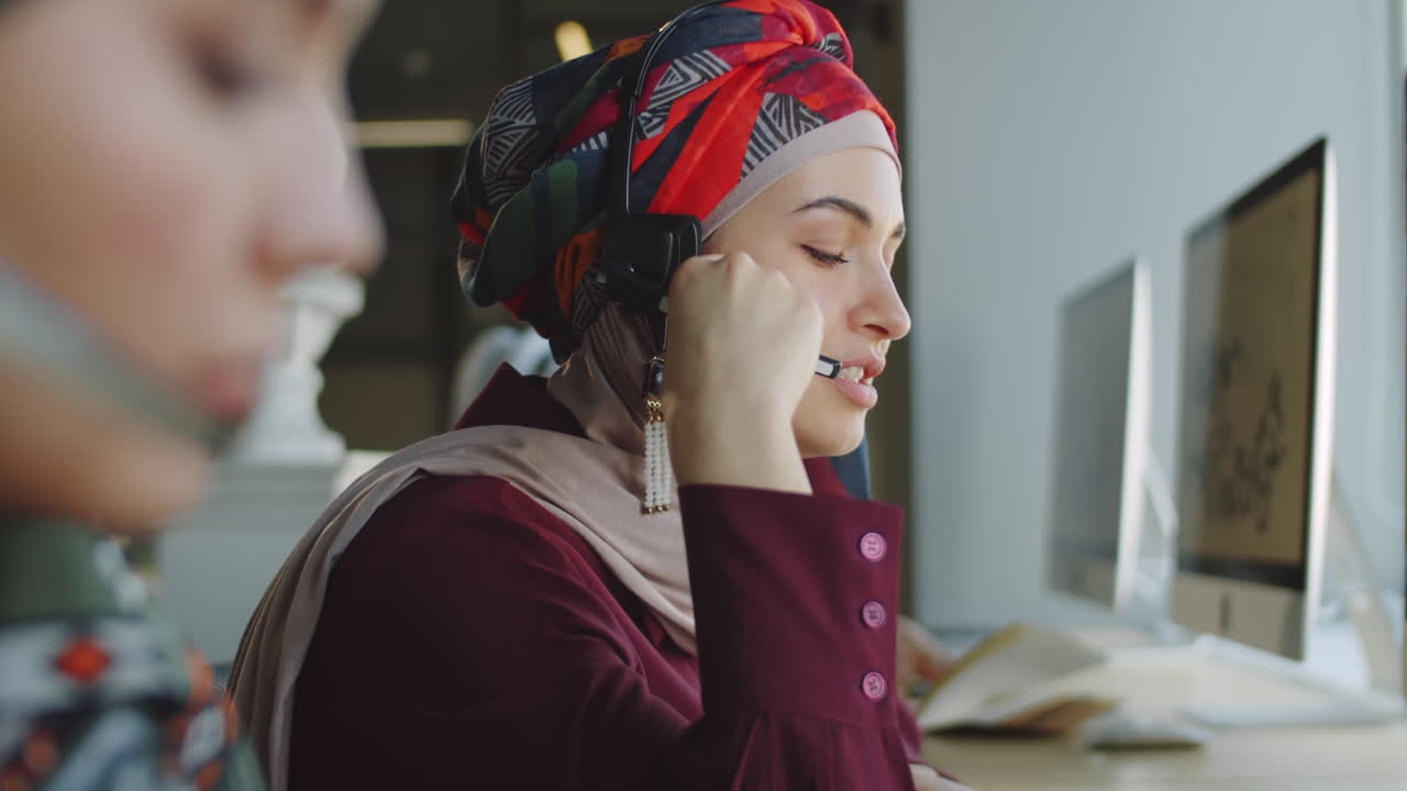 mulher muçulmana com fones de ouvido e hijab trabalhando em um call center