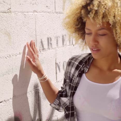 mujer caminando por un muro de piedra