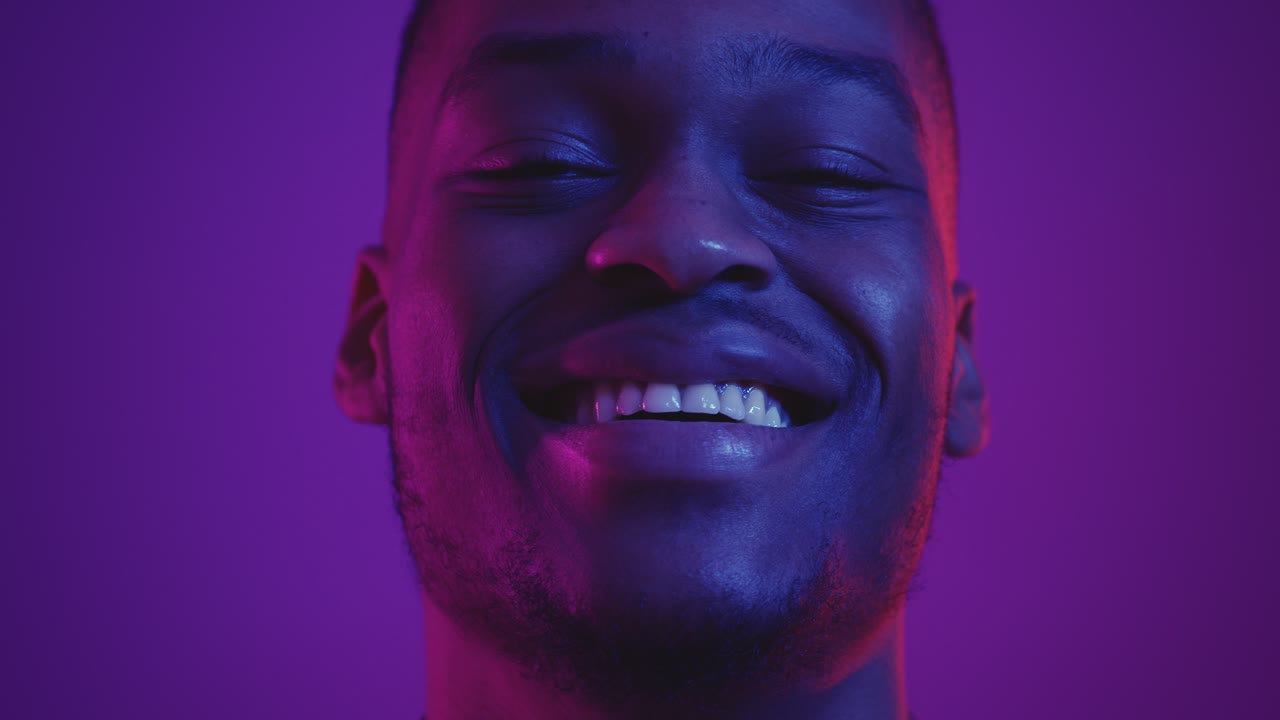 retrato en primer plano de un hombre sonriente en una iluminación vibrante