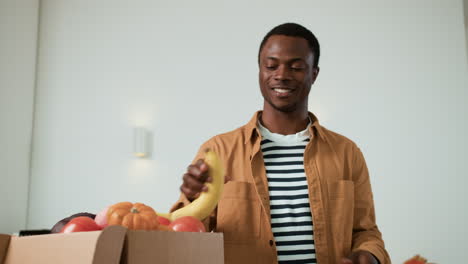 man unpacking vegetables