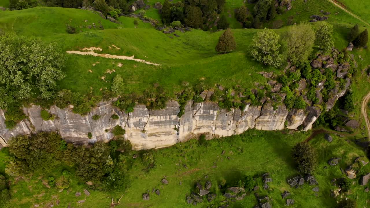 formación de pared de roca mahoenui con colinas verdes, campos y árboles en primavera en waikato, isla norte de nueva zelanda