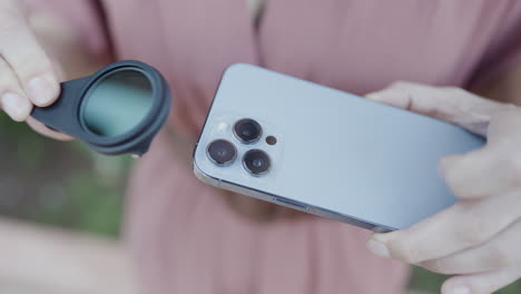 persona que conecta un filtro de lente de la cámara a un teléfono inteligente