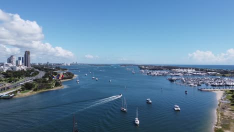 Drone-Ascendiendo-Sobre-Una-Bahía-Y-Un-Puerto-Con-Barcos