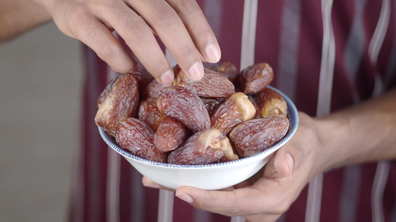 Person Holding a Bowl of Fresh Dried Dates