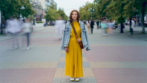 woman in a yellow dress and denim jacket on a city street