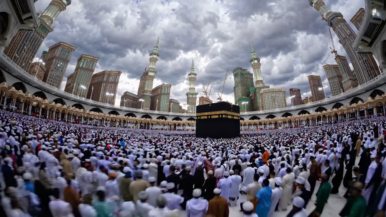 Wide-angle video captures a vast crowd in white garments encircling the Kaaba, with dramatic clouds