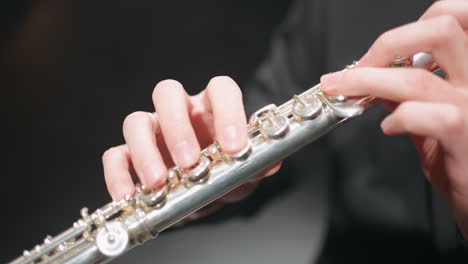manos masculinas y músico de flauta está tocando en banda de bronce o orquesta sinfónica macro disparo