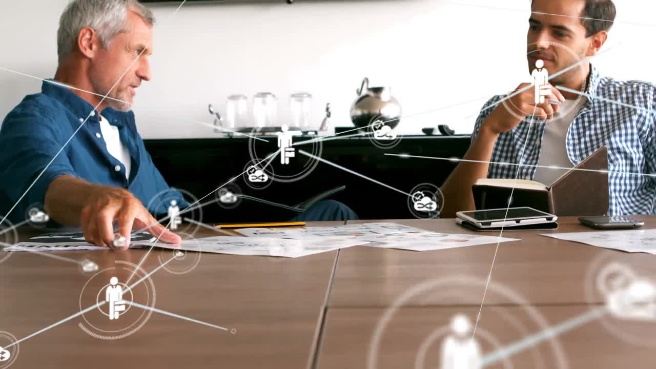 анимация сети цифровых икон над двумя белыми мужчинами, обсуждающими документы в офисе.