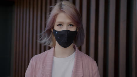 young woman wearing a mask in a stylish outfit