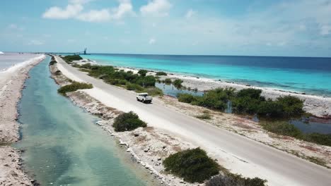 Aerial-view-of-a-car-traveling-along-the-Salt-Pans-road,-in-Bonaire,-the-Dutch-Caribbean