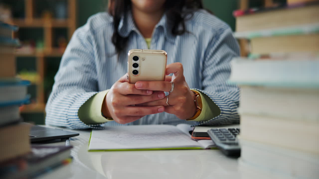 Woman using smartphone while studying