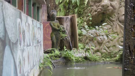 A-fountain-adorned-with-moss,-located-at-the-entrance-to-Kanto-Lampo-Waterfall-in-Bali,-Indonesia