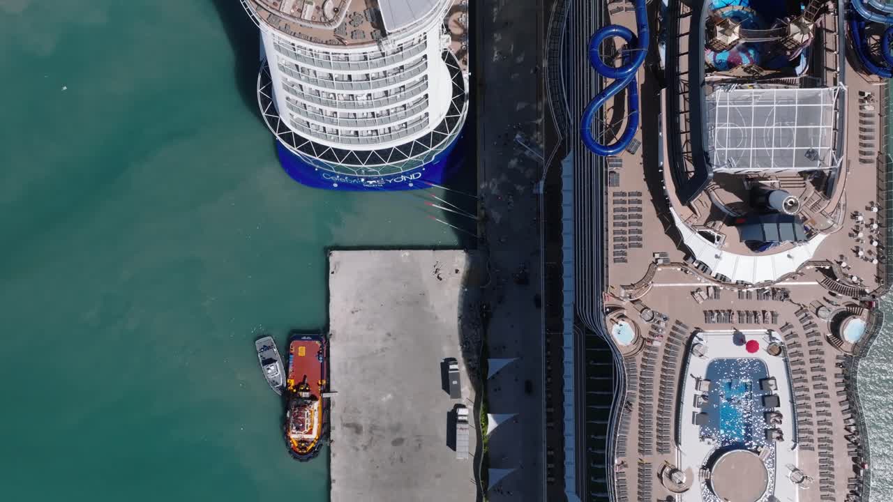 toma aérea de arriba hacia abajo que muestra la piscina en la azotea de un crucero de lujo con humo en aumento en la bahía de taino
