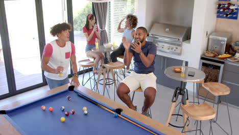 playing pool and socializing, diverse friends enjoying fun hangout at home