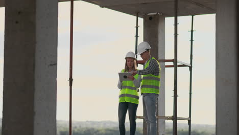 equipo de construcción o arquitecto y constructor o trabajador con cascos discuten un plan de construcción de andamios o un plan o una lista de comprobación