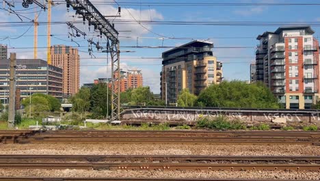 mirando por una ventana de un tren que viaja hacia el norte a través de las afueras de una ciudad