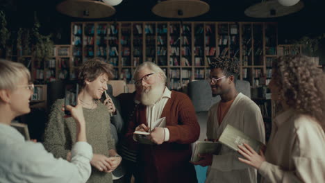 group of fans taking photos with elderly author at book signing event