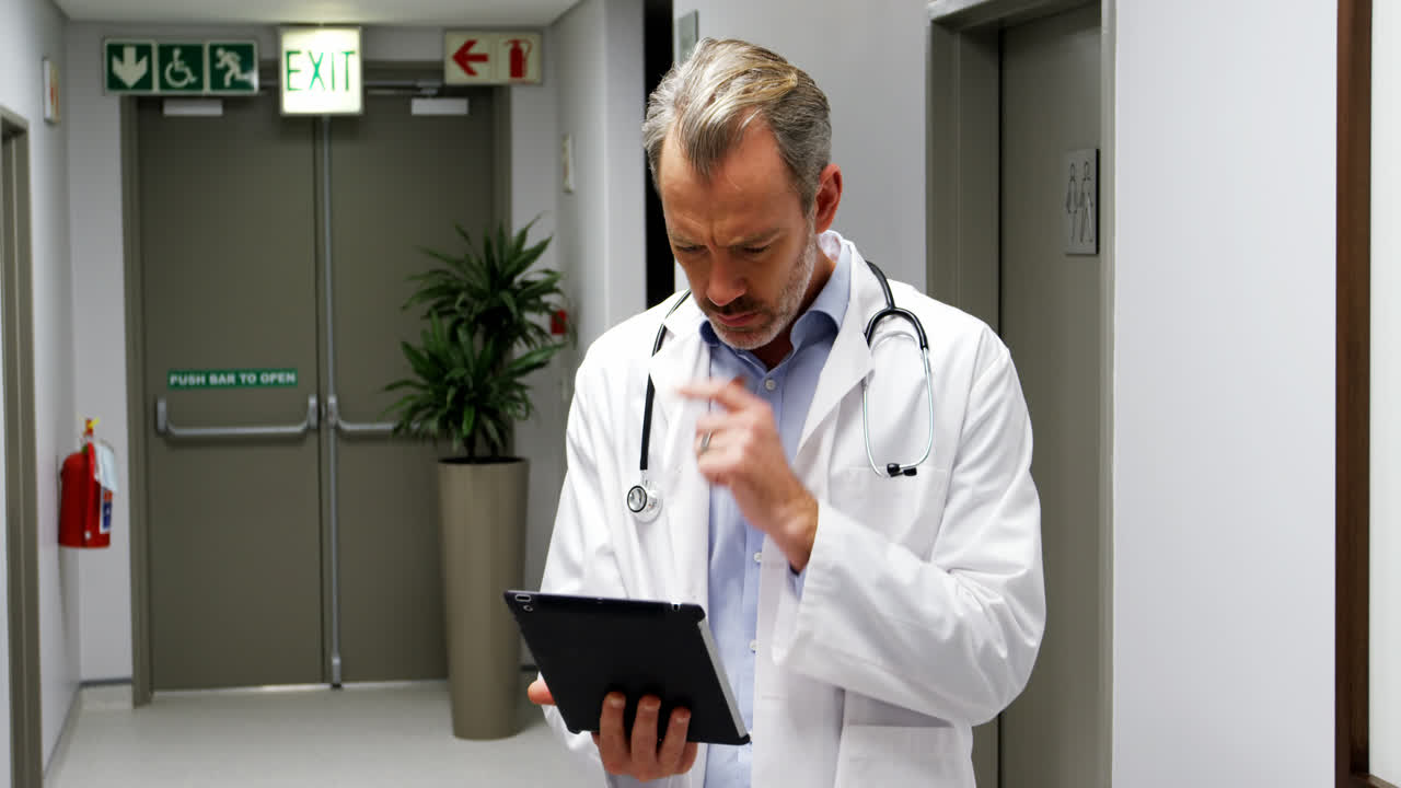 Medico maschio che per mezzo della compressa digitale