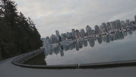 wide rotating shot of a stanley park trail and boats in marina, morning vancouver west end, slowmotion