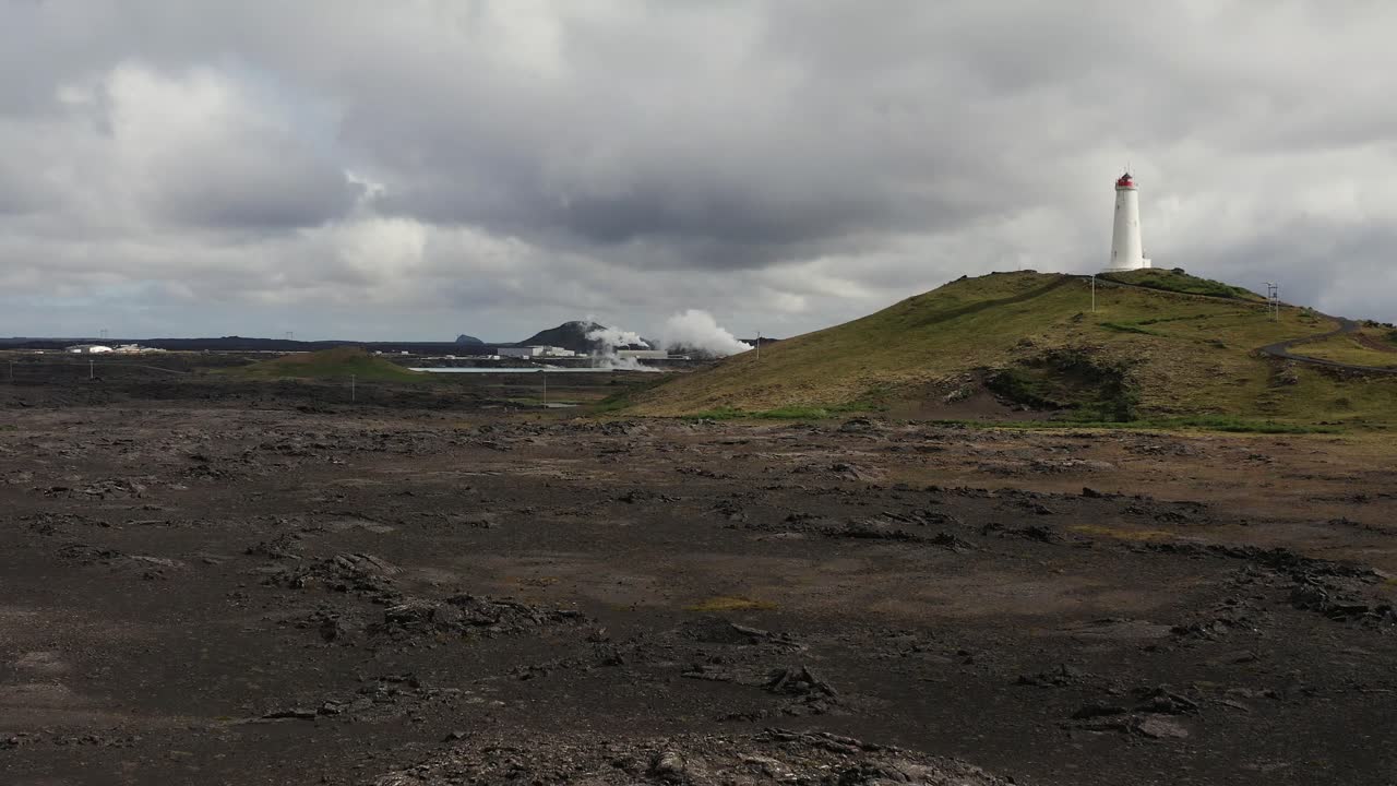 언덕 위에 상징적인 레이캬네스비티 등대가 있는 아이슬란드의 화산 풍경