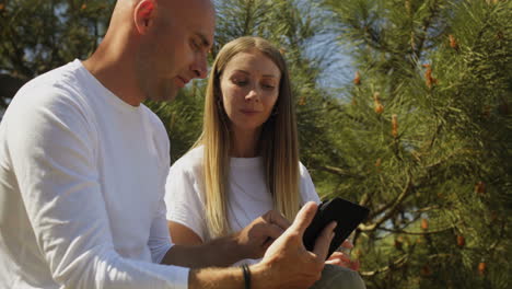 couple talking and using tablet pc outdoor