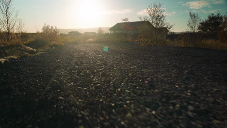 low angle moving down a gravel road at sunset - animal pov close to the ground