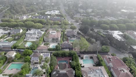 top down aerial shot flying over beverly hills city in early morning fog