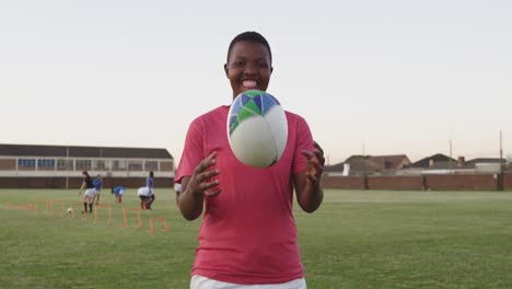 portrait of young adult female rugby player on a rugby pitch