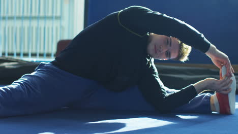 hombre estirándose en un gimnasio