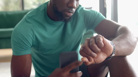checking smartwatch, strong and fit man relaxing at home spa setting