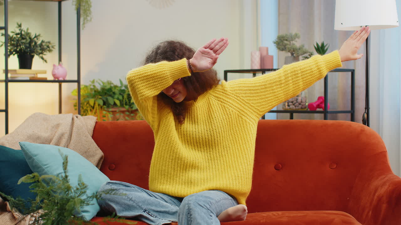 행복한 유아 어린이 소녀가 춤을 추고 리 ⁇ 에 따라 움직이며 현대 가정에서 트렌디한  ⁇  댄스 제스처를 만 ⁇ 니다.