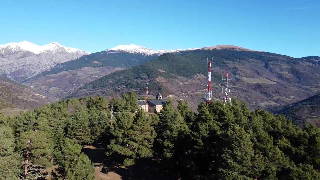 drone volando sobre un bosque para revelar una iglesia medieval en las montañas