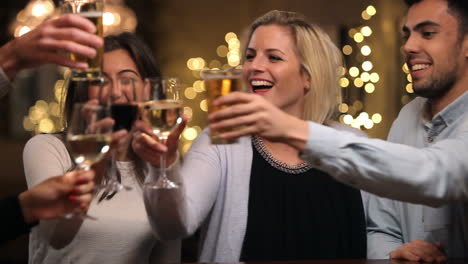 grupo de amigos disfrutando de bebidas por la noche en el bar