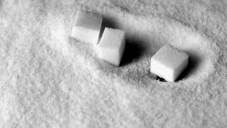 sugar cubes falling in pile of sugar