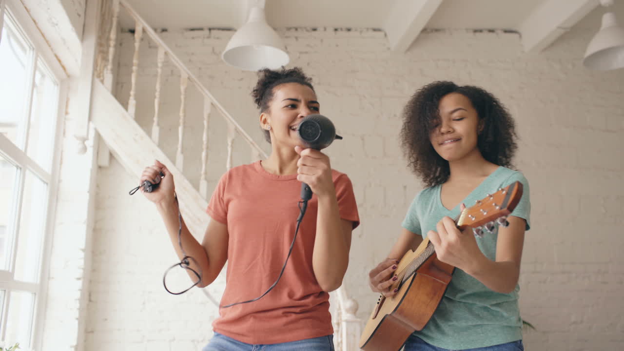 Two girls singing and playing guitar