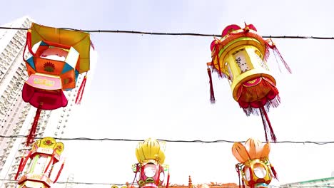 colorful lanterns sway above temple visitors