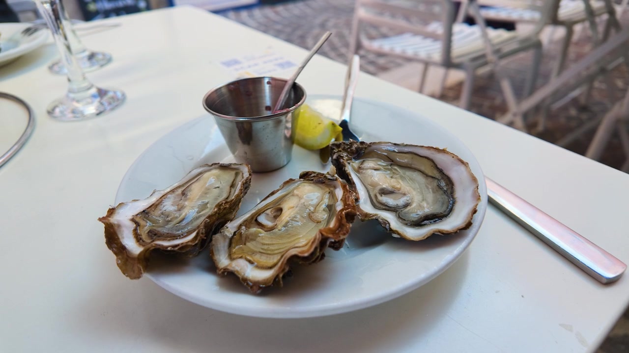Un primo piano di ostriche fresche crude con limone e salsa mignonette su un tavolo