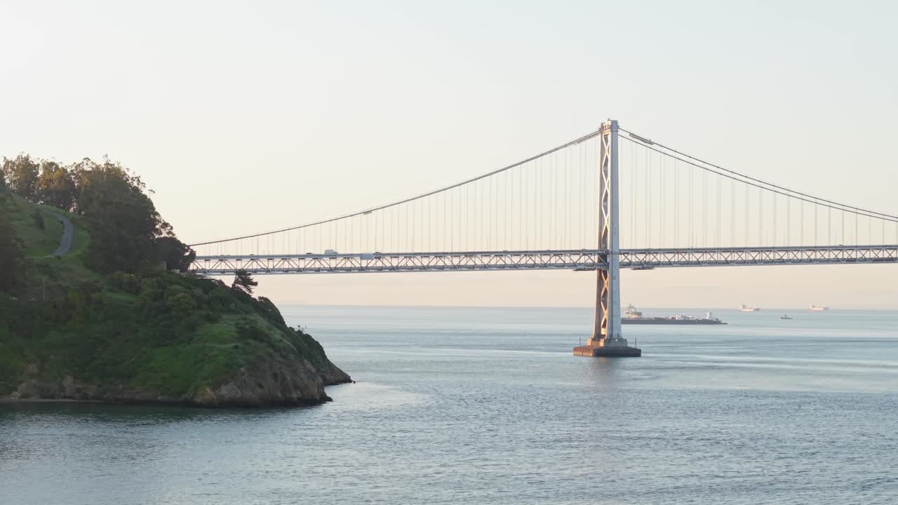 A slow panning view of the San Francisco Bay Bridge as cars drive across it.