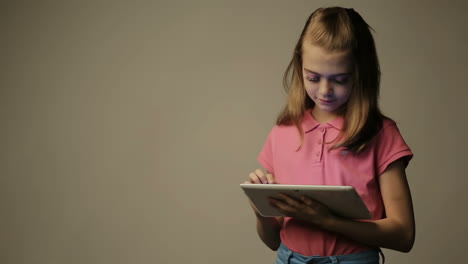 child girl reads and touches on a tablet device