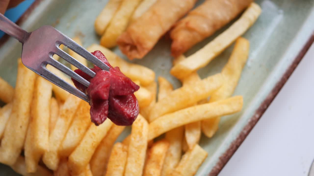 patatas fritas, rollos de primavera y salchichas en un tenedor