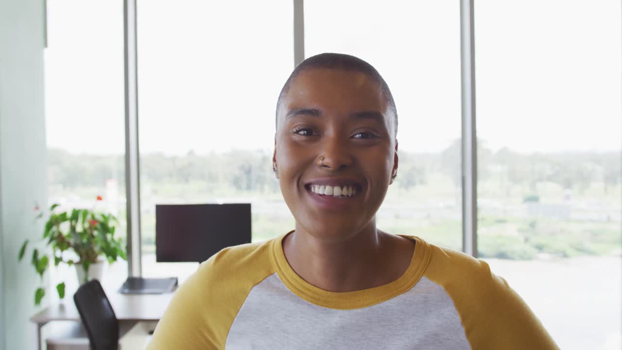 Ritratto di donna d'affari creativa afroamericana sorridente in un moderno ufficio.