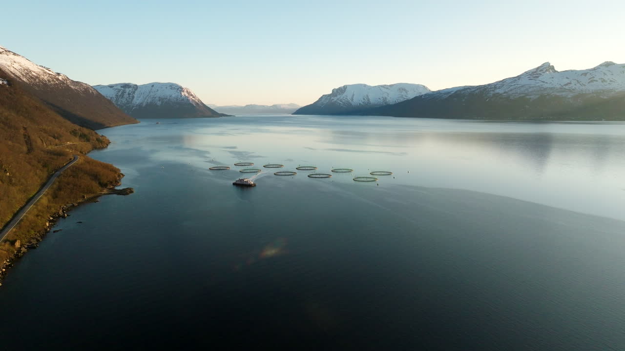 Weite Luftaufnahme über die Lachsfarm Gratangen im Fjord während der Mitternachtssonne, Norwegen