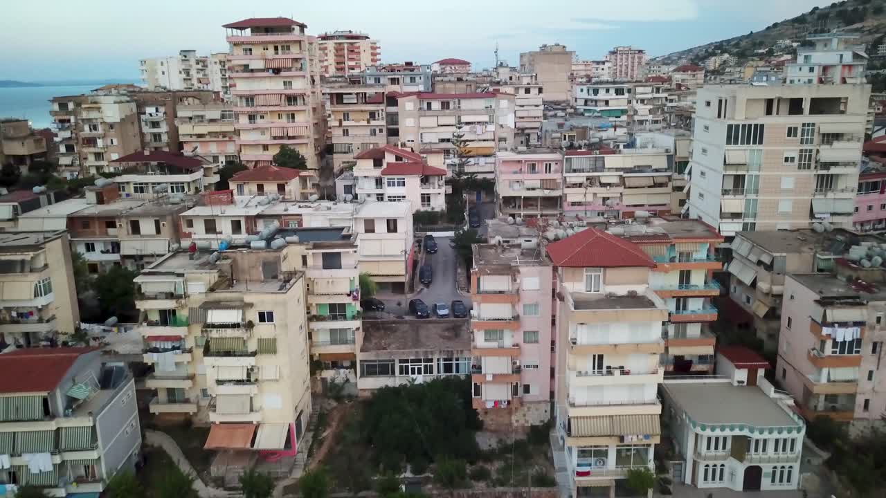 vista aérea alejándose de las desgastadas viviendas de clase baja de albania frente a la costa