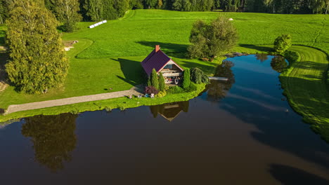 hyperlapse over latvian farmland with house on a small lake from an aerial drone