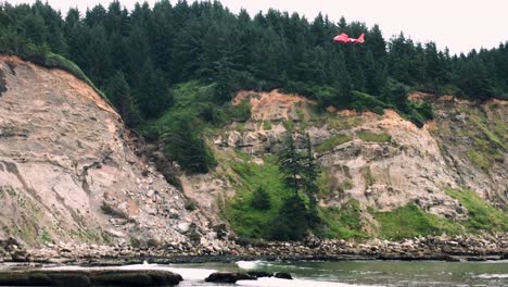 coast guard helicopter hovers above the cliffs where hikers fell