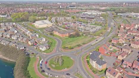 drone view over doncaster lakeside featuring a large roundabout, residential streets, a lakefront edge, and parking-filled retail area, capturing the suburban grid and traffic circulation from above