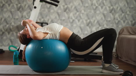 woman doing a workout with an exercise ball at home